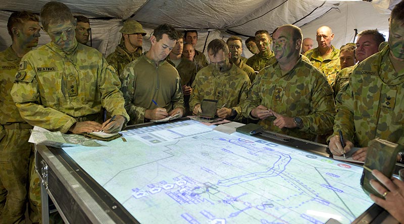Commander 3rd Brigadier Roger Noble briefs subordinates before a brigade live-fire activity using a networked electronic battle management system display. Photo by Corporal David Cotton.