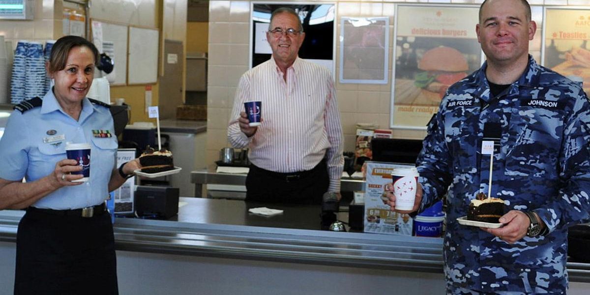 Veteran Paul Beraldo with Squadron Leaders Robyn Connell and Dane Johnson inside the Army and Air Force Canteen Service at RAAF Laverton.