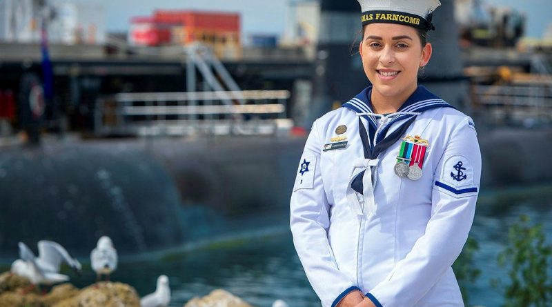 Leading Seaman Elizabeth McCallum in front of HMAS Collins at Fleet Base West in Rockingham, WA. Story by Lieutenant Rilana Ostheim. Photo by Leading Seaman Richard Cordell.