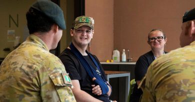 Corporal Brenton Munro, left, from the 6th Battalion, Royal Australian Regiment, talks with 14-year-old Knox Scott and his mother Lauren at Ronald McDonald House, South Brisbane. Photo by Corporal Nicole Dorrett.