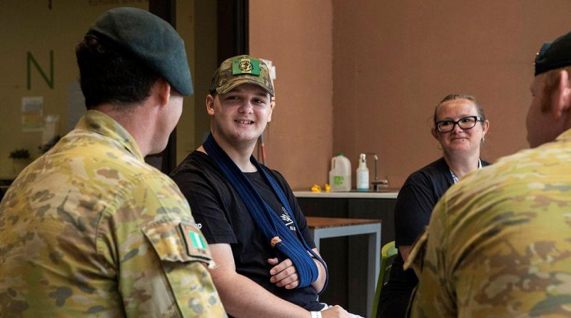 Corporal Brenton Munro, left, from the 6th Battalion, Royal Australian Regiment, talks with 14-year-old Knox Scott and his mother Lauren at Ronald McDonald House, South Brisbane. Photo by Corporal Nicole Dorrett.