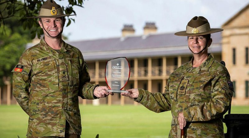 Commander Forces Command Major General Matthew Pearse and Command Sergeant Major Warrant Officer Class One Kim Felmingham hold the trophy on behalf of Army at Victoria Barracks, Sydney. Story by Private Jacob Joseph. Photo by Sergeant Nunu Campos.
