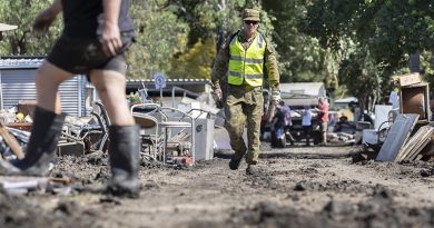 An Australian Army soldier deployed on Operation NSW Flood Assist walks between debris from flood damage in Wisemans Ferry, New South Wales. Photo by Corporal Sagi Biederman.