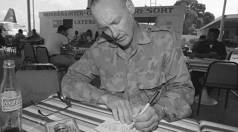 Officer Commanding BASG at Baidoa, Somalia, takes time out to write a postcard home. Photo by Corporal Gary Ramage.
