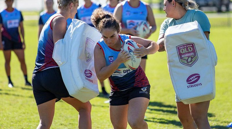 Private Kiara Hawkins from the Australian Defence Force Woman's Rugby League team charges the hit pads during a training session at Leslie Patrick Park in Arana Hills, Brisbane. Story by Private Jacob Joseph. Photo by Leading Seaman Steve Thomson.