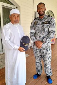 Able Seaman Boatswains Mate Ebrahim Dollie presents the Imam of Cocos Keeling Islands Mosque with an HMAS Glenelg ball cap, representing the ship in which he serves. Photo by Lance Corporal Flannagan.