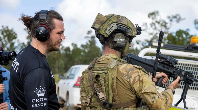 Captain Declan James explains the workings of an EF88 Austeyr Rifle to former South Sydney Rabbitoh player Ethan Lowe during his visit to Shoalwater Bay Training Area, Queensland. Story by Captain Jesse Robilliard. Photo by Corporal Nicole Dorrett.