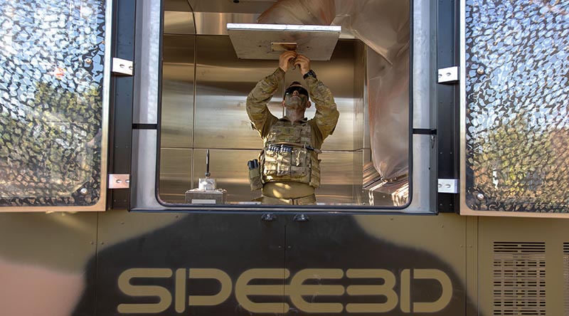 Lance Corporal Sean Barton, 1st Combat Service Support Battalion, prepares a WarpSPEE3D printer for parts manufacture during Exercise Buffalo Run at Mount Bundey Training Area, NT. Photo by Corporal Rodrigo Villablanca.