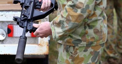 An Australian soldier examines a F90 (EF88) assault rifle with attached suppressor on display at the Thales small arms range at Lithgow. Photo by Corporal Nick Wiseman.