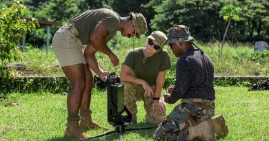 Private Osama Ahmed, left, Lieutenant Amy Rowlings and Vanuatu Police Maritime Wing Constable Sione Motoutorua connect the antenna to the Epi Island’s Police Post radio mast. Story by Corporal Olivia Cameron. Photo by Corporal Olivia Cameron.