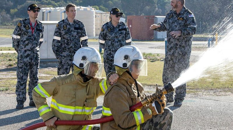 Senator for Victoria, Senator Raff Ciccone, Member for Ryan, Julian Simmonds and Senator for NSW Senator Hollie Hughes listening to Senior Instructor Chief Petty Officer Bryce Jackson explain fire hose techniques. Photo by Petty Officer Yuri Ramsey.