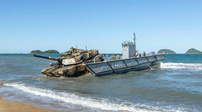 An Australian Army M1A1 Abrams Tank is loaded onto a Royal Australian Navy light landing craft, during Exercise Sea Explorer, Cowley Beach, Queensland. Story by Photo by Leading Aircraftwoman Jacqueline Forrester.