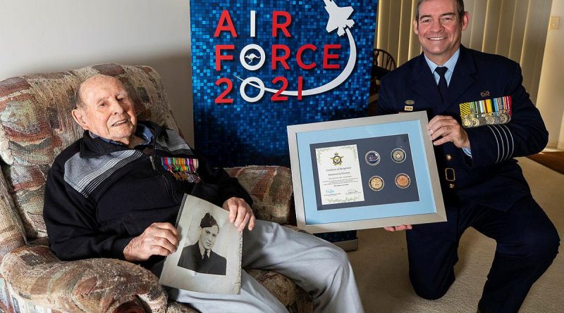 Senior ADF Officer RAAF Base Amberley Group Captain Iain Carty presents Air Force veteran Bill Heatherill with an Air Force 2021 commemorative memento in celebration of his 100th birthday. Story by Evita Ryan. Photo by Corporal Jesse Kane.