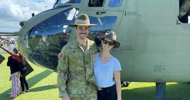 Lance Corporal Brendan Cox and his partner, Holly Fowler, stand in front of an Australian Army CH47F Chinook helicopter.