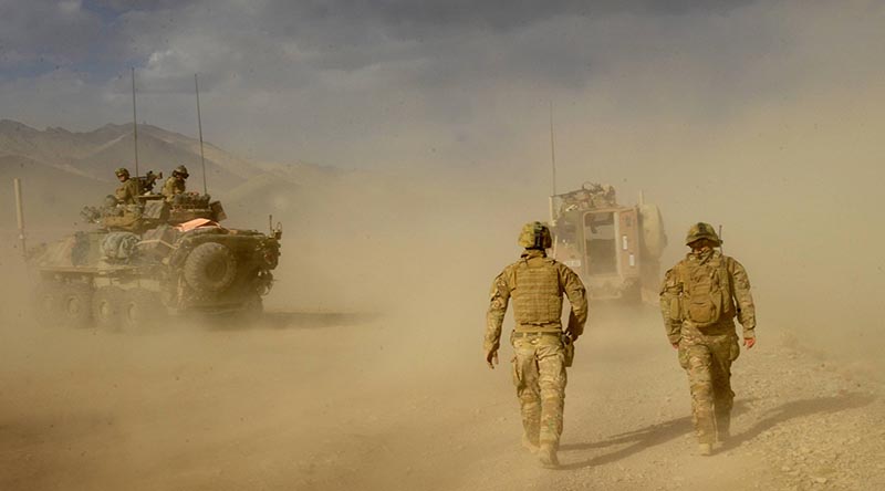 Soldiers from Mentoring Task Force – Three (MTF-3) move away from a helicopter landing zone, after loading Australian casualties wounded by an improvised explosive device on a Bushmaster, in the Chora Valley, southern Afghanistan. Photo by Able Seaman Jo Dilorenzo.