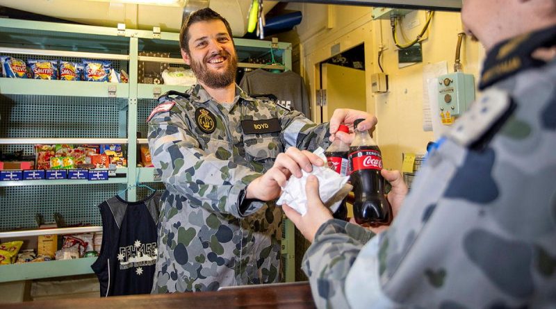 HMAS Ballarat's Assistant Canteen Manager Leading Seaman Timothy Boyd serves Able Seaman Daniel Johnson during deployment. Story by Lieutenant Geoff Long. Photo by Leading Seaman Ernesto Sanchez.