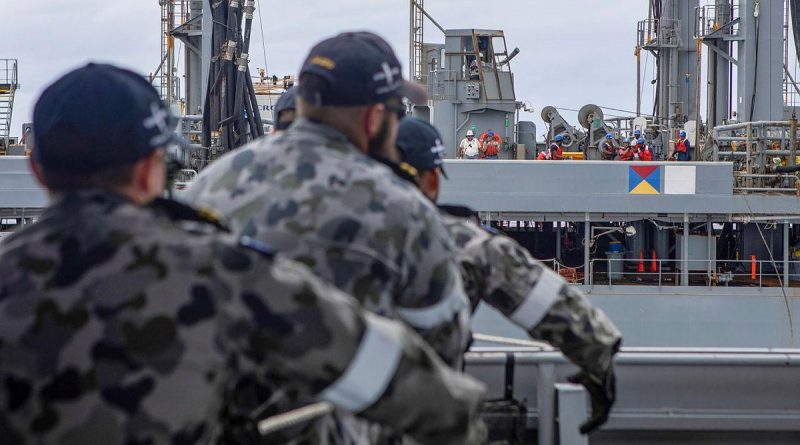 HMAS Ballarat's Ship's Company heave in a messenger line during a replenishment at sea with USNS Big Horn. Story by Lieutenant Gary McHugh. Photo by Leading Seaman Ernesto Sanchez.