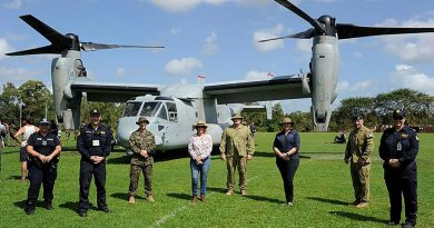 Community leaders and representatives from the NT Police and Australian Border Force stand with ADF and US Marine Corps members in front of an MV-22B Osprey. Story by Lieutenant Gordon Carr-Greg.