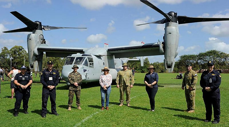 Community leaders and representatives from the NT Police and Australian Border Force stand with ADF and US Marine Corps members in front of an MV-22B Osprey. Story by Lieutenant Gordon Carr-Greg.