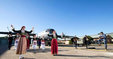 Dancers from the Cretan Association of Sydney perform in front of a C-130J Hercules as No. 37 Squadron avionics technician Leading Aircraftman Yianni Skoulakis, right, plays the laouto at RAAF Base Richmond. Story by Eamon Hamilton. Photo by Corporal David Said.
