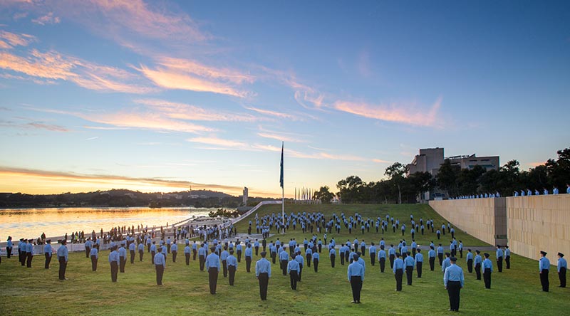 Australian Defence Force Academy Air Force trainee officers stand at attention during the raising of the RAAF Ensign at Commonwealth Place on 31 March 2021. Photo by Lannon Harley.