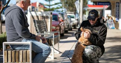 Able Seaman Tegan Bradley pats an Eden resident’s dog during the ship’s company’s walk into the NSW town during a port visit. Story by Acting Sub Lieutenant Jack Meadows. Photo by Leading Seaman Daniel Goodman.