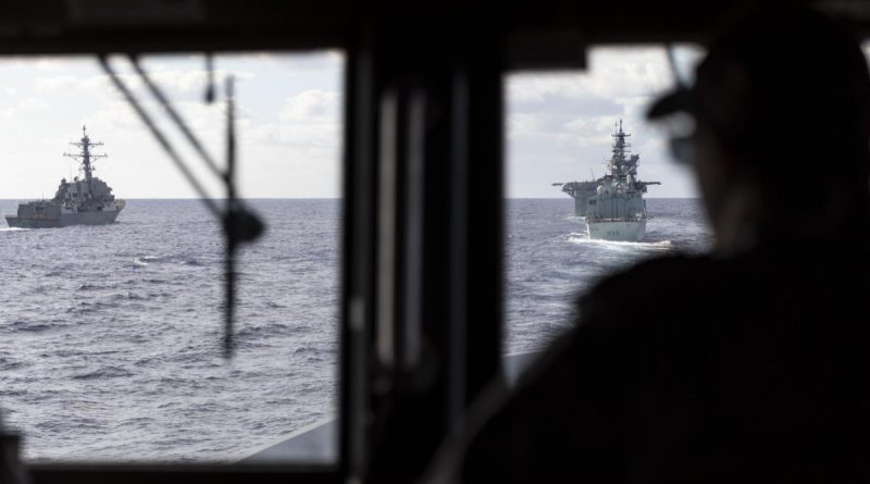 HMAS Brisbane’s Navigating Officer, Lieutenant Marita Knack, looks on as the ship sails astern of (L to R) USS Rafael Peralta, USS America and HMCS Calgary off the coast of QLD, during Exercise Talisman Sabre 2021. Story by Lieutenant Sarah Rohweder. Photo by Leading Seaman Daniel Goodman.