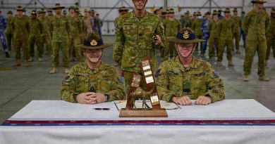 Rear Admiral Michael Rothwell, left, and Air Commodore David Paddison, right, after signing the Transfer of Authority for Command of Joint Task Force 633, witnessed by Warrant Officer Class One Mark Retallick. Photo by Sergeant Andrew Sleeman.