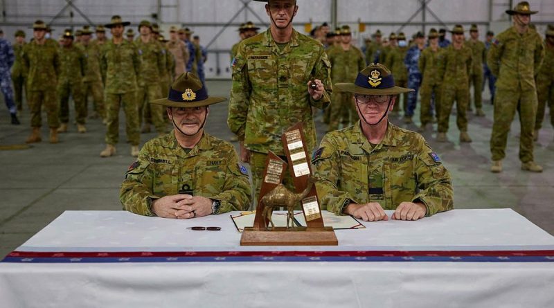 Rear Admiral Michael Rothwell, left, and Air Commodore David Paddison, right, after signing the Transfer of Authority for Command of Joint Task Force 633, witnessed by Warrant Officer Class One Mark Retallick. Photo by Sergeant Andrew Sleeman.