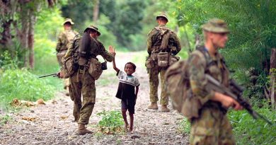 Boy greets Aussie soldiers on patrol in East Timor, Photo by Corporal Brian Hartigan.