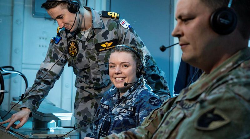 US Army’s Chief Warrant Officer 2 Robert Schenk, right, Air Force’s Flight Lieutenant Rebekah Johnson-Costigan and Navy’s Lieutenant Michael Van Den Berg in HMAS Brisbane's operations room. Story by Lieutenant Sarah Rohweder. Photo by Leading Seaman Daniel Goodman.