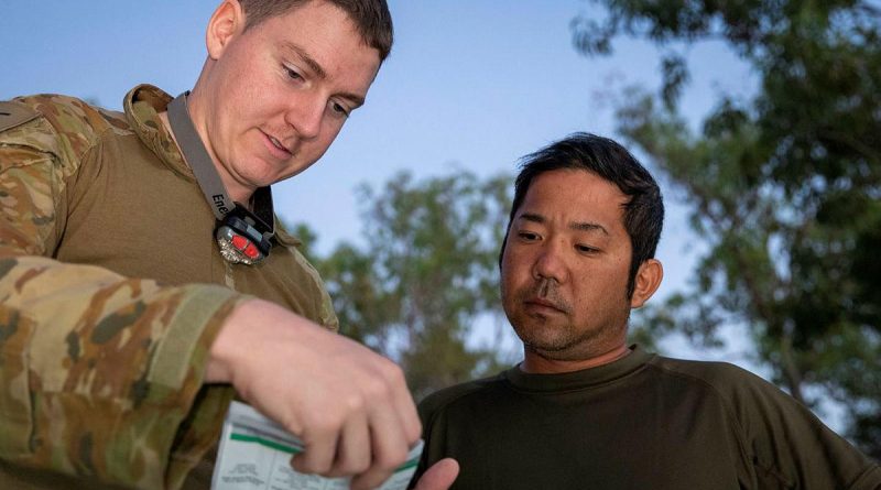 Army linguist Lance Corporal Cameron Murdoch talks with Japan Ground Self-Defense Force soldier Sergeant First Class Shigeyuki Azuma during Exercise Southern Jackaroo. Story and photo by Private Jacob Joseph.