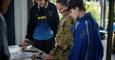 Warrant Officer Class One Kelly Hammant instructs students from Redbank Plains State High School how to paint boomerangs in traditional styles. Story by Captain Jesse Robilliard. Photo by Private Jacob Hilton.