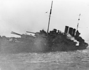 The stricken HMAS Canberra (I) following the action at Savo Island. After being struck by at least two Japanese torpedoes and numerous enemy salvos, she was deemed unsalvageable and consequently evacuated and sunk off Savo Island on 9 August 1942. RAN file photo.