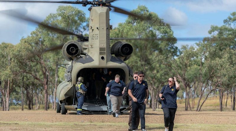 Australian Institute of Sport representatives exit a CH-47 Chinook at the Townsville Field Training Area during a visit to the Command Training Centre in Townsville, Queensland. Story by Paulina Acuna. Photo by Corporal Sagi Biderm.