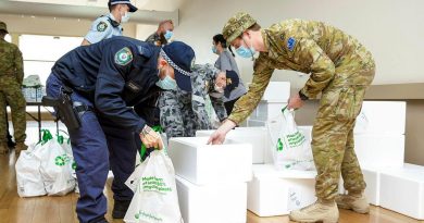 NSW Police and ADF members prepare to deliver pre-made meals as part of care packages given to homes in the Fairfield community in Sydney. Story by Lieutenant Commander John Thompson. Photo by Corporal Dustin Anderson.