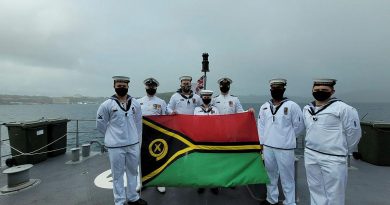 Personnel from HMAS Glenelg, with Commanding Officer Lieutenant Commander Alexander Finnis, third from right, display the Vanuatu flag while at anchor at Port Vila during Vanuatu's Independence Day celebrations. Story by Lieutenant Sarah Rohweder.
