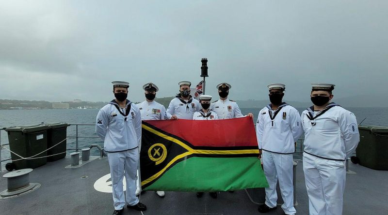 Personnel from HMAS Glenelg, with Commanding Officer Lieutenant Commander Alexander Finnis, third from right, display the Vanuatu flag while at anchor at Port Vila during Vanuatu's Independence Day celebrations. Story by Lieutenant Sarah Rohweder.