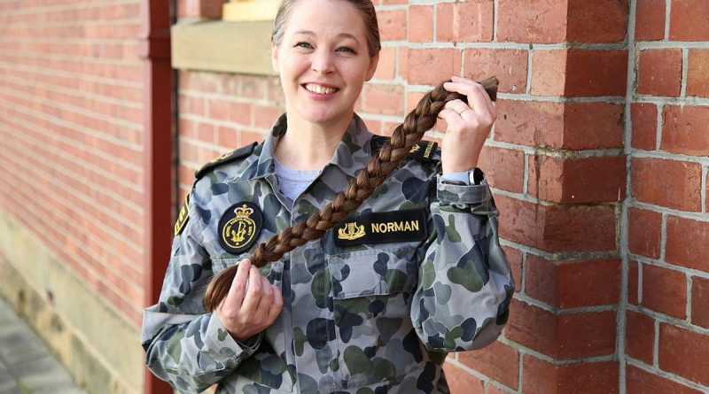 Leading Seaman Musician Miriam Norman from the Royal Australian Navy Band Tasmania shows of the braid of hair she has donated to charity.