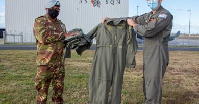 Captain Randall Hepota of the Papua New Guinea Defence Force is presented with flying clothing during his visit to No. 35 Squadron at RAAF Base Amberley by Squadron Leader Robert Crawford. Story by Flight Lieutenant Clarice Hurren. Photo by Sergeant Peter Borys.