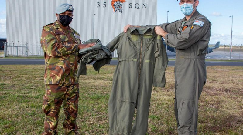 Captain Randall Hepota of the Papua New Guinea Defence Force is presented with flying clothing during his visit to No. 35 Squadron at RAAF Base Amberley by Squadron Leader Robert Crawford. Story by Flight Lieutenant Clarice Hurren. Photo by Sergeant Peter Borys.