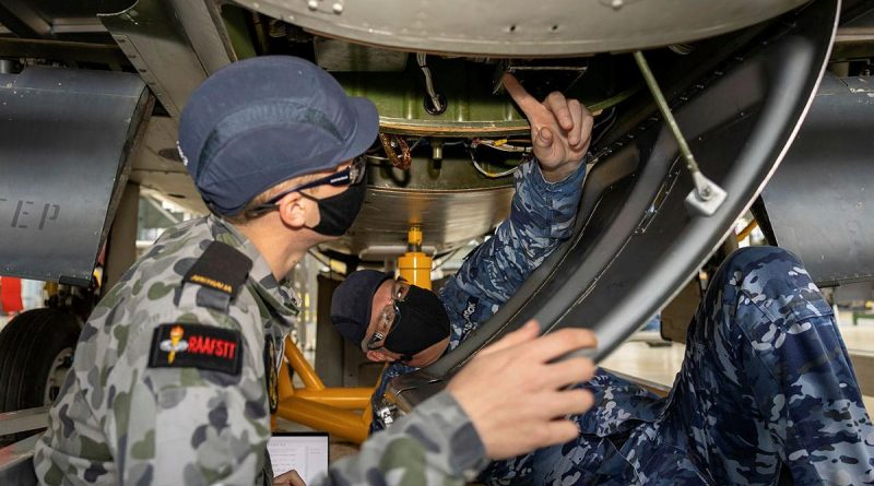 Corporal Andrew Ashbrook, right, helps avionics technician trainee Seaman William Cook to identify, recover and replace a faulty voltage regulator. Story by Flight Lieutenant Julia Ravell.