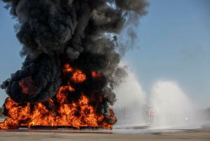 Royal Australian Air Force No. 23 Squadron Aviation Rescue and Fire Fighting vehicles begin to apply fluorine free foam to extinguish a large demonstration aviation fuel blaze. Photo by Sergeant Andrew Eddie.