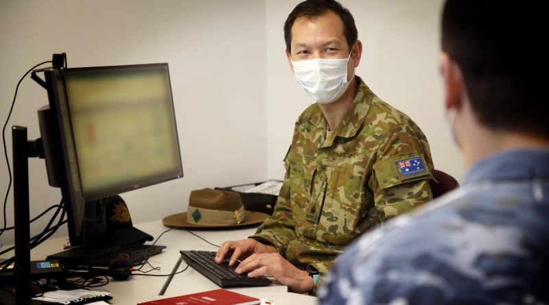 Major Timothy Chan, Officer Commanding Bravo Company, Joint Task Force 629.1.1, works with a member of the task force at HMAS Kuttabul, Sydney. This image has been digitally altered. Photo by Aircraftwoman Kate Czerny.