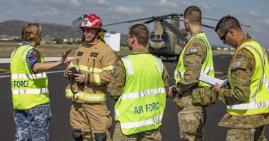 Medical officer Flight Lieutenant Melanie Smyth gives the fire commander from Aviation Rescue Fire Fighting Services and fellow Air Force members a situation report on the crash victims. Story by Flying Officer Robert Hodgson. Photo by Corporal Jesse Kane.