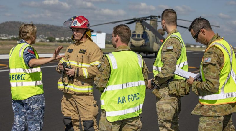 Medical officer Flight Lieutenant Melanie Smyth gives the fire commander from Aviation Rescue Fire Fighting Services and fellow Air Force members a situation report on the crash victims. Story by Flying Officer Robert Hodgson. Photo by Corporal Jesse Kane.