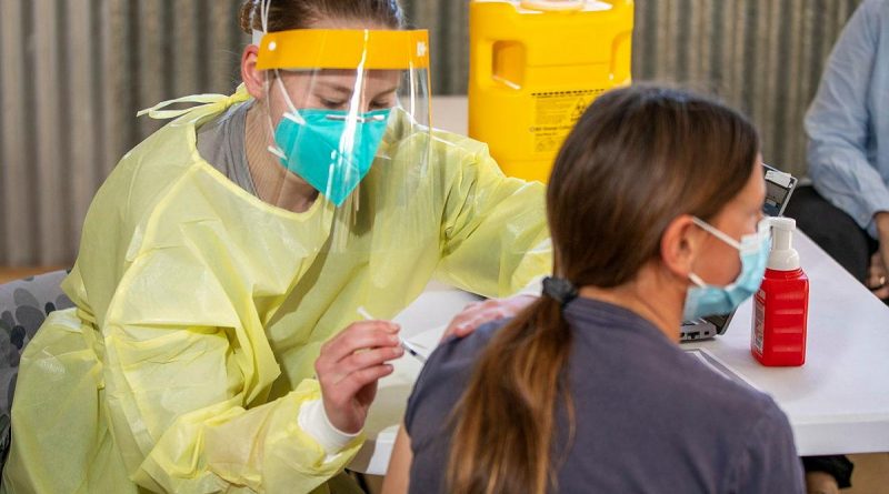 Navy medic Seaman Alana Leonard, from HMAS Penguin, administers a COVID-19 vaccination at the Vaccination Outreach Clinic at the Nyngan Showgrounds, NSW, Story by Lieutenant Brendan Trembath. Photo by Chief Petty Officer Cameron Martin.