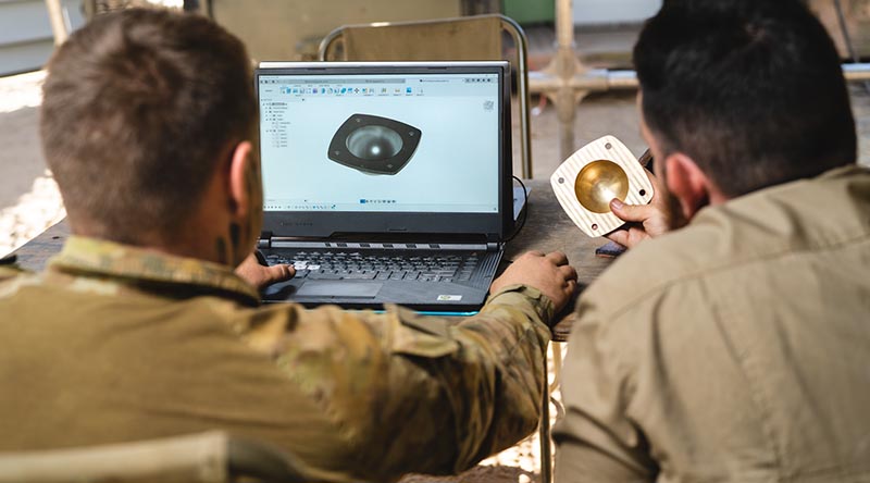 Specialist soldiers use a WarpSPEE3D Tactical printer to make a wheel-bearing hub for an M-113 APC at Bradshaw Field Training Area, NT, during Exercise Koolendong. Photo supplied. 