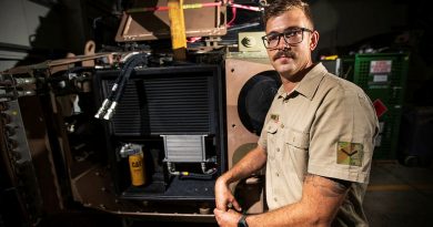 Australian Army Vehicle Mechanic Lance Corporal Timothy Pates in front of a protective mobility vehicle prepared for deep clean at Australia's main operating base in the Middle East. Photo by Sergeant Glen McCarthy.