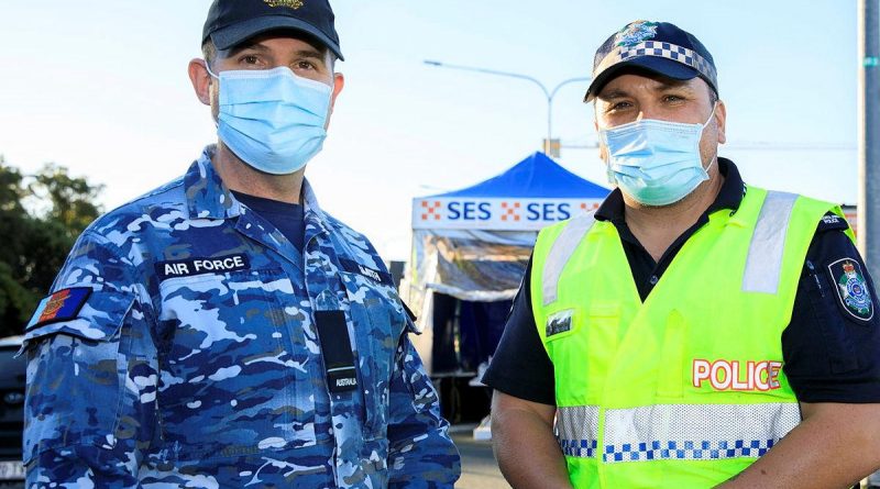 Flying Officer Brett Smith talks with his mate and former colleague Senior Constable Jared Cowan at the Gold Coast Highway police checkpoint. Story by Lieutenant Nicolas Hawkins. Photo by Corporal Brett Sherriff.